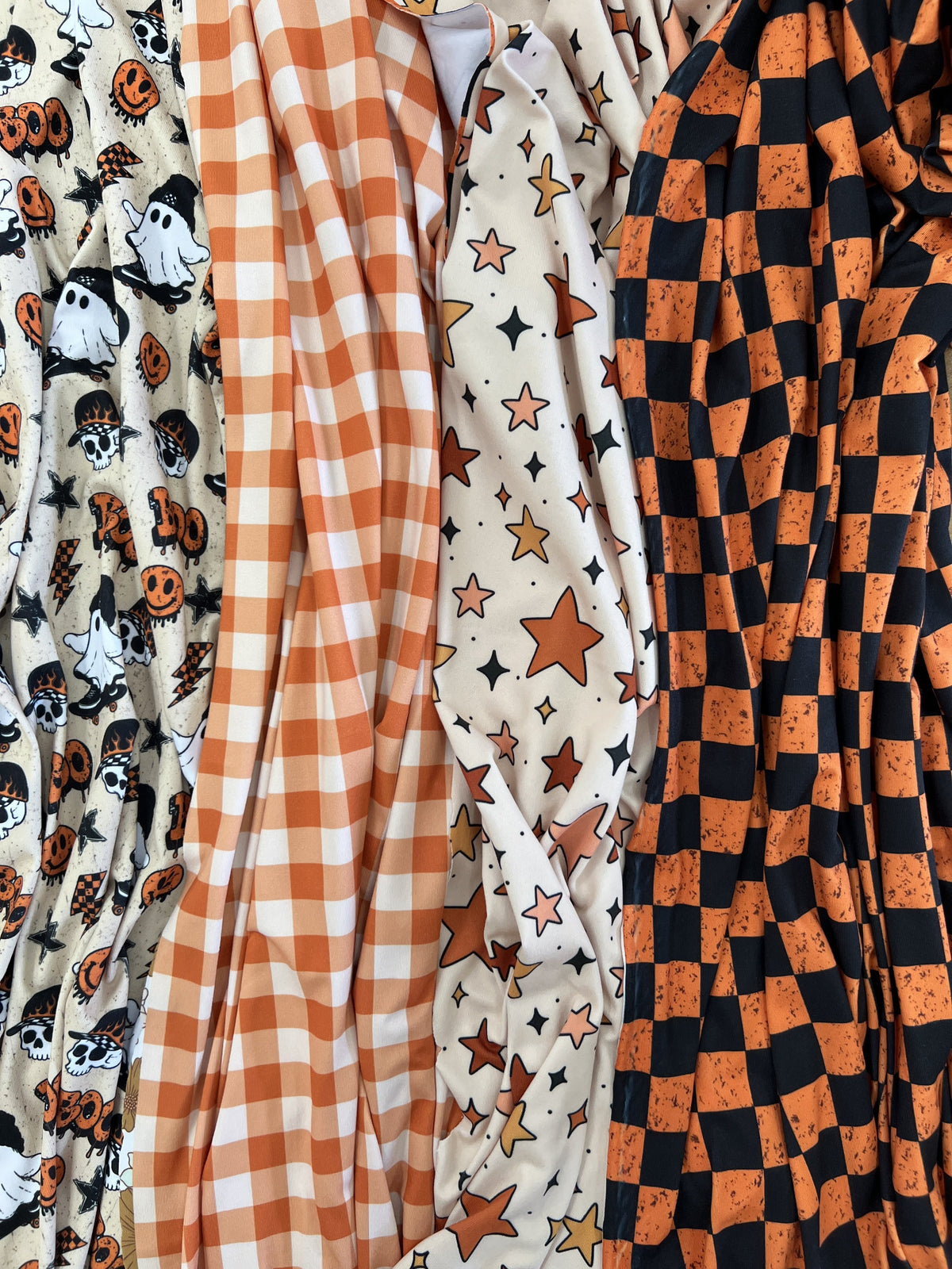 Printed fabric draped in folds, orange checkerboard, stars and gingham